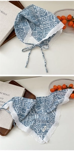 Detail of light blue cotton scarf with white lace trim and geometric print pattern