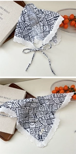 Detail of cotton linen triangle scarf with black geometric prints and lace borders