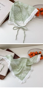 Detail of green cotton linen scarf with white fern leaf patterns and delicate lace trim