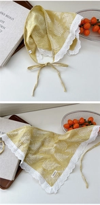 Detail of yellow cotton linen scarf featuring white leaf print and delicate lace trim