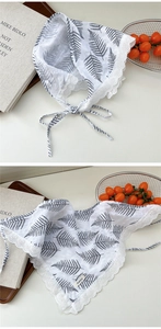 Detail of white cotton lace scarf featuring black fern leaf print and woven brand label