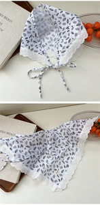 Close-up of white cotton linen triangle scarf with black leaf print and lace trim edges