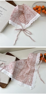 Close-up of pink paisley cotton scarf featuring delicate white lace trim and ties