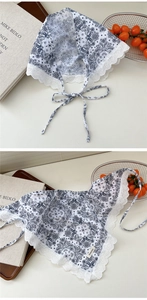 Close-up of white paisley bandana with delicate lace edges and vintage floral pattern