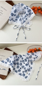 Close-up of white cotton floral scarf with blue flower print and lace edge detailing