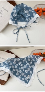 Detail of floral lace trim on blue cotton-linen neck scarf with delicate hollow-out edges
