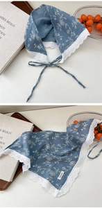 Detailed close-up of blue floral cotton linen scarf with white lace trim and ties