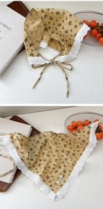 Detailed texture of ginger yellow floral cotton headscarf with white heart lace trim