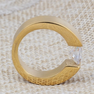 Macro side view of an 8mm gold-plated stainless steel tension set solitaire stone ring