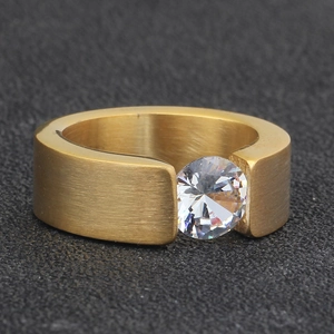 Detail of 8mm gold stainless steel ring with brushed finish and tension-set round zircon