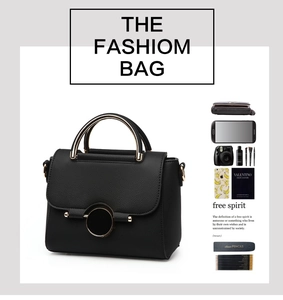 Detail view of black pebbled leather handbag with round gold lock and matching metal handle