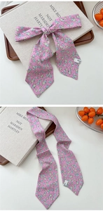 Detailed view of pink floral skinny scarf with pointed ends and elegant silk texture