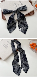 Detail of French paisley pattern silk scarf tied in a bow with elegant vintage aesthetic