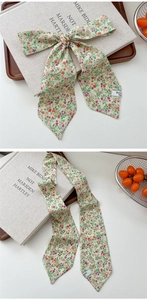 Detail of floral skinny silk scarf showing the delicate print and elegant bow knot