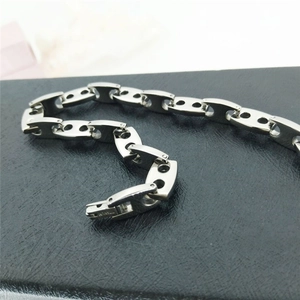 Macro view of industrial 316L titanium link bracelet showing brushed metal texture and clasp