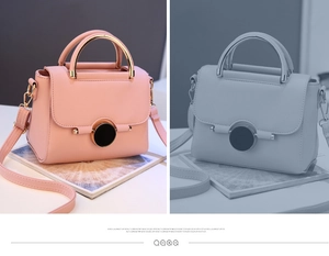 Detail of light pink lychee pattern bag with gold metal handle and round magnetic buckle