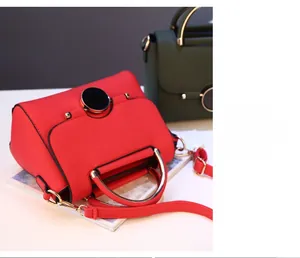 Detail view of fashion leather handbags featuring circular metal lock and top handles