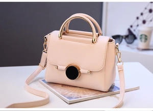 Detail of lychee pattern leather handbag with gold metal handle and luxury lock
