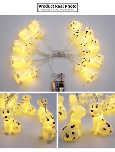 Detail view of cartoon Dalmatian LED string lights with warm yellow glow and battery box
