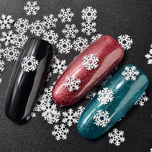 White snowflake nail art sequins on diverse glitter gel polish bases for winter DIY