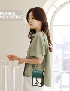 Detail of green and beige crossbody bag featuring floral embroidery and slim strap