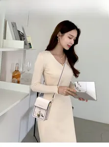 Chic cream crossbody phone bag with dog illustration styled on a ribbed dress