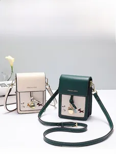 Close-up of minimalist crossbody phone bags with dog illustrations and metal charms