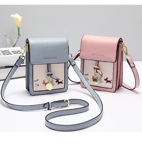 Close-up of pink and blue mini phone bags with puppy embroidery and metal charms