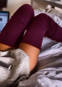Detail of burgundy ribbed knit over-the-knee socks showing thick cotton texture