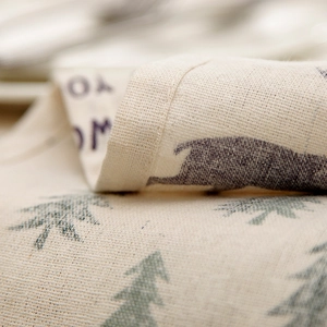 Close-up of linen fabric texture with Christmas pine tree print and rustic folds