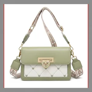 Détail du sac bandoulière en cuir vert clair et blanc avec boucle cœur et motif matelassé