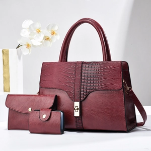 Detailed set of burgundy crocodile pattern handbag with matching envelope clutch and card holder