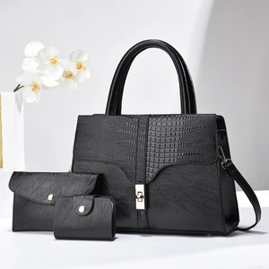 Detailed set of black leather tote with crocodile pattern flap and golden hardware