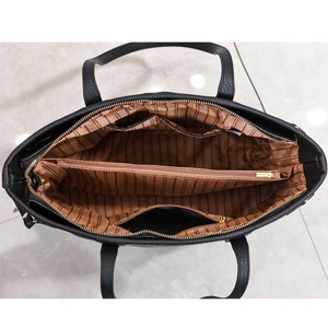 Interior view of black tote bag showing striped lining and functional compartments