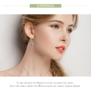 Model wearing s925 silver bee earrings with brown crystals and elegant wings