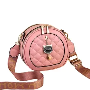 Sac bandoulière rond rose matelassé avec détails dorés et large sangle tissée