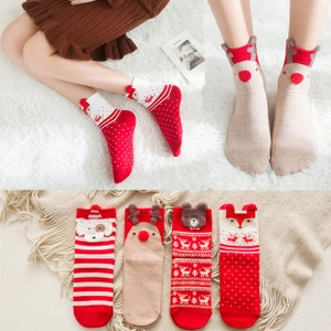 Detail of Christmas cartoon socks featuring reindeer and fox patterns on knitted cotton