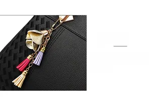 Détail du sac à main noir texturé avec pendentif pompon floral coloré et doré