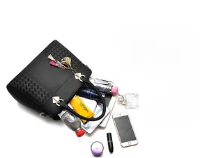 Détail d'un sac à main noir avec texture tressée et grande capacité de rangement interne