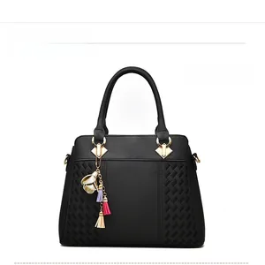 Détail du sac à main en cuir grainé noir avec texture tressée et garniture dorée