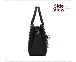 Vue latérale d'un sac à main noir en cuir avec anneau en D doré et détail de pompon