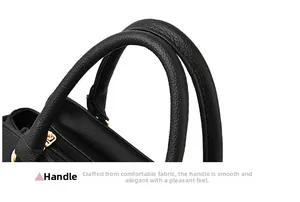Détail d'un sac à main en cuir grainé noir avec double poignées et boucles dorées