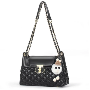 Chic black quilted crossbody bag with golden T-lock and cute plush monster charm