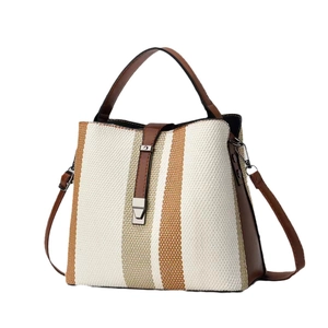 Three-color vertical stripe woven tote bag with brown leather handles and shoulder strap