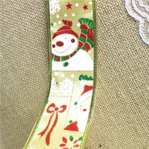 Close-up of 2-meter gold Christmas ribbon with snowman prints on rustic burlap