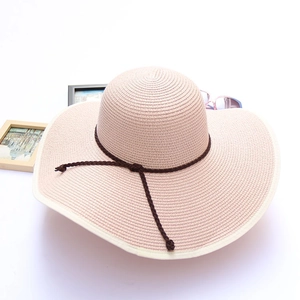 Pink wide-brimmed sun straw hat with dark brown woven ribbon bow for summer beach vacation