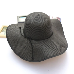 Women's black wide brim straw sun hat with decorative ribbon for beach vacations