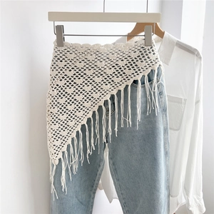 Detail of crochet cotton triangle scarf featuring shell patterns and long fringe tassels