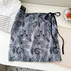Detail of light blue lace skirt with floral embroidery and black drawstring waist