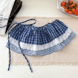 Détail de la jupe de taille à carreaux bleus avec dentelle blanche et étiquette